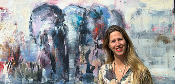 Konstnären Karin Holmström framför en målning av en elefant.
