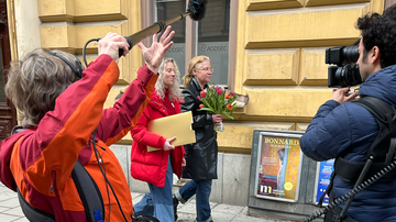 Två personer går och blir filmade på en stadsgata